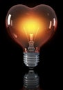 Classical light bulb, heart shaped, glowing yellow red Royalty Free Stock Photo