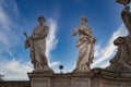 Classical marble statues against blue sky, Vatican.