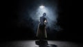 Silhouette of female on black background under spotlight projector in studio. Ballerina in white tulle dancing slow Royalty Free Stock Photo