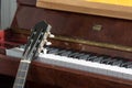 Classical music. Acoustic guitar resting on an old piano close-up Royalty Free Stock Photo