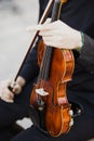 Classical musicians hold their musical instrument, a violin, while reading their score