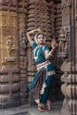 Classical Odissi dancer looks at the mirror at Mukteshvara Temple,Bhubaneswar, Odisha, India