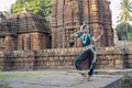 Landscape view of Classical Odissi dancer looks at the mirror at Mukteshvara Temple,Bhubaneswar, Odisha, India