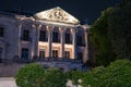 Classical ornate building facade with ornate pediment above six pillars