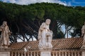 Classical statues on Vatican building terrace amidst surveillance technology, Rome. Royalty Free Stock Photo