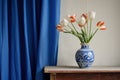 Classical still life with a blue white hand painted vase and tulips, blue curtains in the background