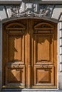 Antique double door entrance of old building in Paris France. Vintage wooden door panel and stone fretwork relievo details above. Royalty Free Stock Photo