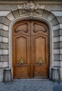 Gorgeous style arch with double door entrance of old building in Paris France. Vintage wooden doorway and stucco fretwork wall Royalty Free Stock Photo