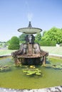 Classical water fountain. Ornamental stone feature in English formal garden.