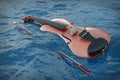 Classical Wooden Violin with Bow in Blue Ocean Waves. 3d Rendering