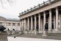 classicist building with columns and sculptures, viewed from a distance