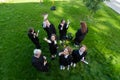 Classmates in graduation gowns throw their caps. View from above.