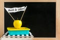 Classroom with books, notebooks, launch box and yellow apple wit