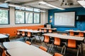 A classroom filled with orange chairs and a large projector screen at the front, ready for a lesson, A lush, modern empty Royalty Free Stock Photo