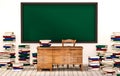 Classroom, green blackboard on white wall with table, chair and piles of books on wooden floor, 3d rendered