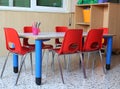 Classroom of a kindergarten with red chairs and small school tab Royalty Free Stock Photo