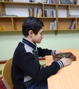 Classroom of the medrese. Muslim boy sitting at a school desk, Quran placed in front of him