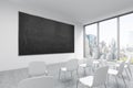 A classroom or presentation room in a modern university or fancy office. White chairs, a black chalkboard on the wall and panorami