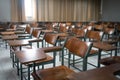 Classroom with a variety of chairs set against the backdrop of windows and a blackboard