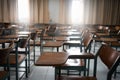 Classroom with a variety of chairs set against the backdrop of windows and a blackboard