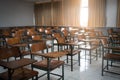 Classroom with a variety of chairs set against the backdrop of windows and a blackboard