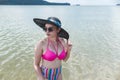 A classy asian lady in a large sun hat, shades and retro high waist bikini at the beach. Summertime theme Royalty Free Stock Photo