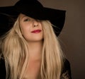 Classy blonde woman wearing a hat, artistic film portrait for fashion campaign and beauty brand Royalty Free Stock Photo