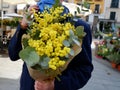 Classy bouquet of yellow mimosa hold by man on the flower market in Madrid, Spain Royalty Free Stock Photo