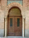 Classy carved wooden doorway of brown warm colour. Restored Andalusian residence in Madrid, Spain. Old-fashioned door made in