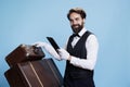 Classy doorman reads bookings on tablet Royalty Free Stock Photo