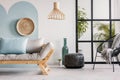 Classy living room interior with scandinavian futon sofa, pouf, armchair and urban jungle Royalty Free Stock Photo