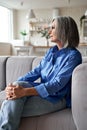Classy relaxed mature older woman relaxing sitting on couch at home. Royalty Free Stock Photo