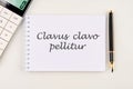 Clavus clavo pellitur. The ancient Greek expression translates as, A wedge is knocked out with a wedge. on a white notebook