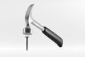 Claw hammer with black plastic handle hitting a nail on white background Royalty Free Stock Photo