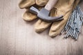 Claw hammer leather protective gloves and heap of metal nails on Royalty Free Stock Photo