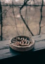 A clay ashtray with butts on a wooden terrace beam Royalty Free Stock Photo
