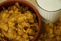 Clay bowl of cornflakes and a glass of milk high-angle shot close up Royalty Free Stock Photo