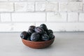 Clay bowl with fresh plums in the kitchen in the style of Scandinavian design Royalty Free Stock Photo