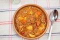 Clay bowl with homemade lentil stew, tomato, Spanish chorizo, meat and potatoes Royalty Free Stock Photo