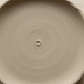 Clay bowl on pottery wheel with smooth texture and circular patterns Royalty Free Stock Photo