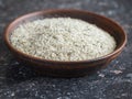 Clay bowl with a spoon filled with salt with herbs on the dark stone table. Royalty Free Stock Photo