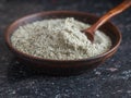 Clay bowl with a spoon filled with salt with herbs on the stone table. Royalty Free Stock Photo