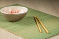 Clay Chinese rice bowl, chopsticks on a green bamboo mat Royalty Free Stock Photo