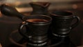 Clay coffee set Cezve and two cups with steaming coffe