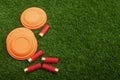 Clay disc flying targets and shotgun shells on artificial grass background ,Clay Pigeon target