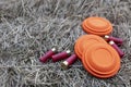 Clay disc flying targets and shotgun shells on straw background ,Clay Pigeon target