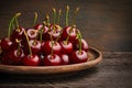 A clay dish filled with ripe cherries. Wooden table in oak