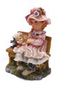 Clay doll display of a young girl and a cat sitting on a wooden bench Royalty Free Stock Photo