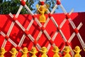 Clay dolls on some Parallelograms structure of wooden sticks tied with red ropes and a red background