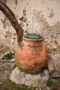 A clay jar with a green lid on an old wall Royalty Free Stock Photo